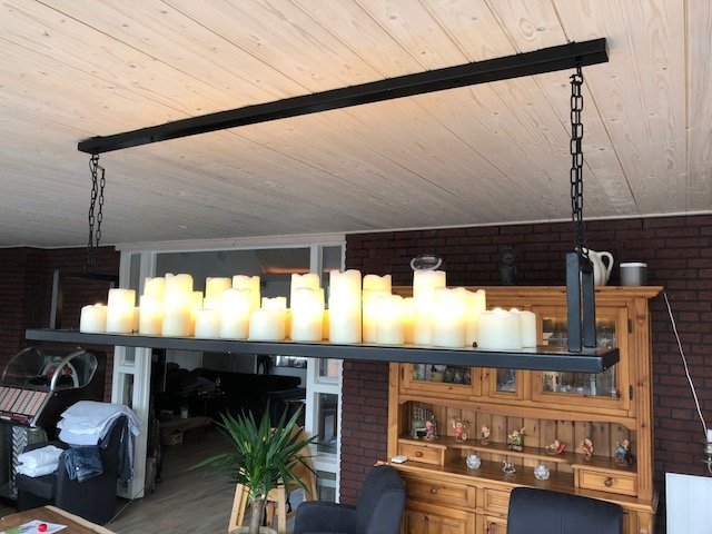 Stalen kaarsenlamp van JudaLevison boven een eettafel
